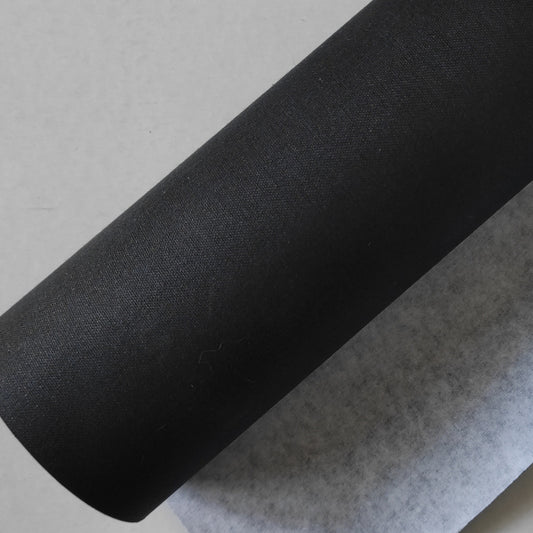 Tela in cotone nera accoppiata a carta per rivestimenti creativi.