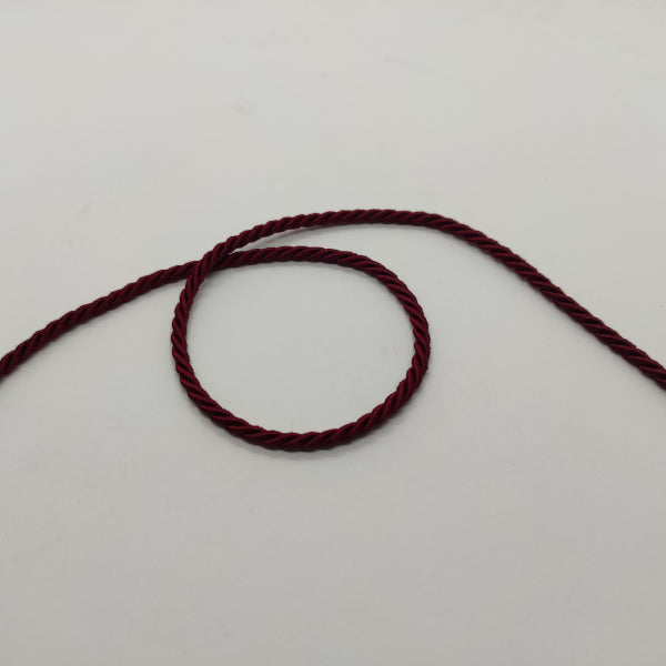 Cordoncino ritorto a 3 capi (composizione acetato e fibra acrilica) dall'aspetto lucido e con colori brillanti. Diametro 3,5 mm - colore bordeaux