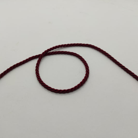 Cordoncino ritorto a 3 capi (composizione acetato e fibra acrilica) dall'aspetto lucido e con colori brillanti. Diametro 3,5 mm - colore bordeaux