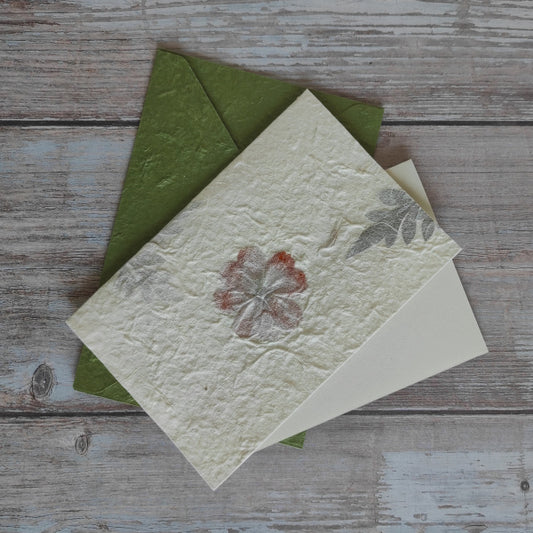 Set biglietto artigianale con carta di gelso “Fiori arancioni e foglie”, foglio interno A5 e busta coordinata colore verde muschio.