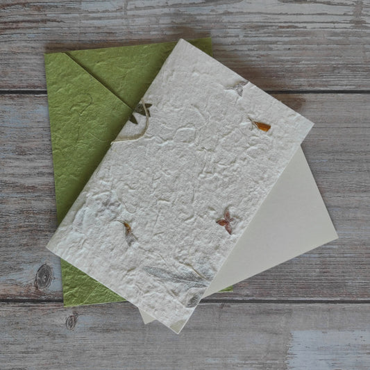 Set biglietto artigianale con carta di gelso “Petali gialli, fiori a stella e foglie”, foglio interno A5 e busta coordinata colore verde menta.