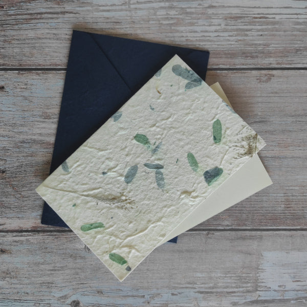 Set biglietto artigianale con carta di gelso “Petali blu e verdi”, foglio interno A5 e busta coordinata colore blu scuro.