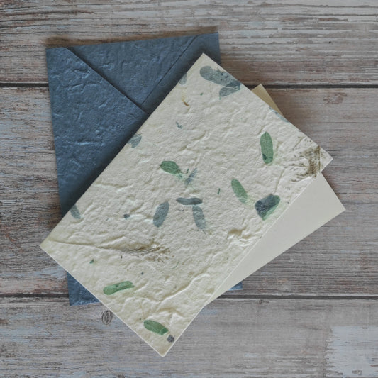 Set biglietto artigianale con carta di gelso “Petali blu e verdi”, foglio interno A5 e busta coordinata colore blu.