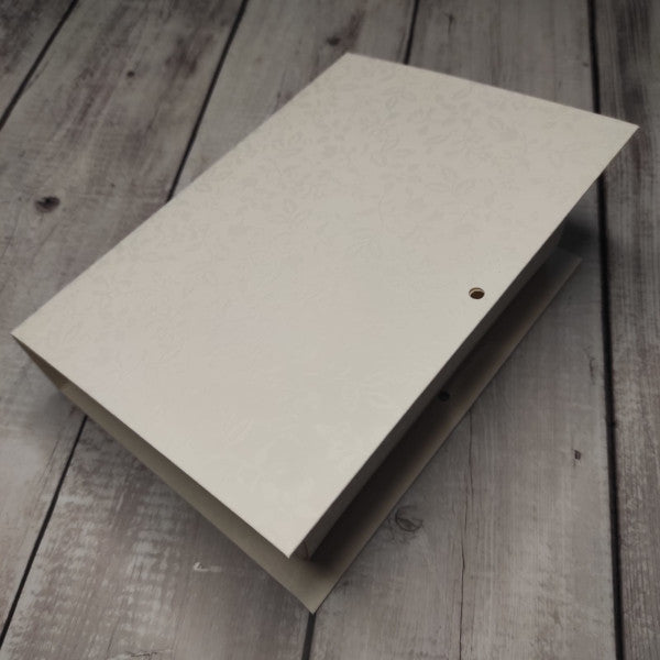 Scatola grande a forma di libro in cartoncino a fantasia floreale tono su tono bianco. Disponibile anche piccola e media