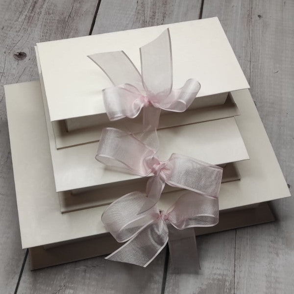 Scatole a forma di libro in cartoncino a fantasia floreale tono su tono bianco. Disponibili in 3 misure