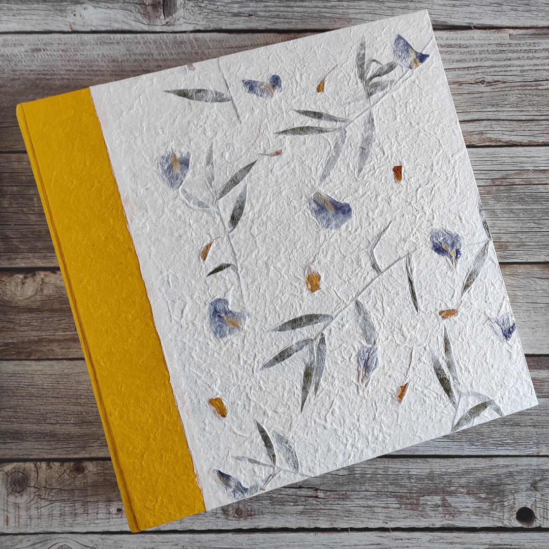 Album fotografico artigianale con copertina a due colori in carta di gelso con fiori blu abbinata a carta di gelso tinta unita ocra