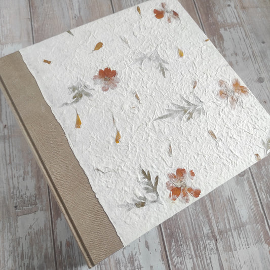 Album fotografico artigianale con copertina a due colori in carta di gelso con fiori arancioni e foglie abbinata a carta Lokta Wax Cotton color terra