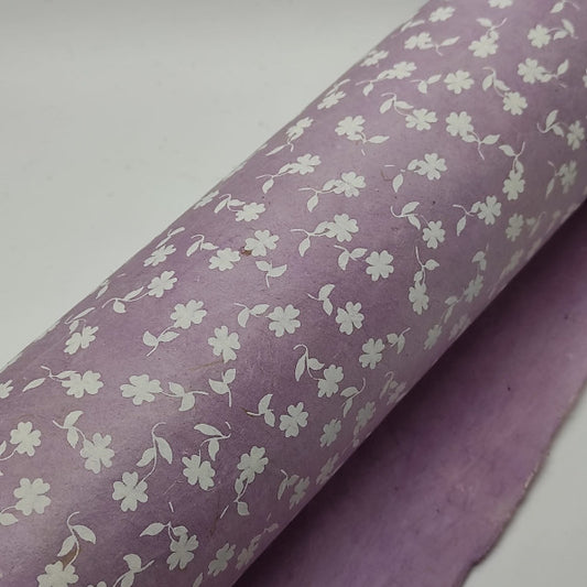 Carta di produzione artigianale nepalese. Stampa di motivi floreali in bianco su fondo lilla